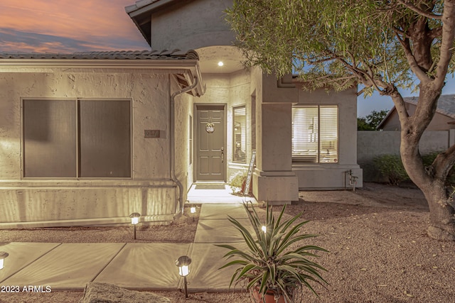 entrance to property featuring stucco siding