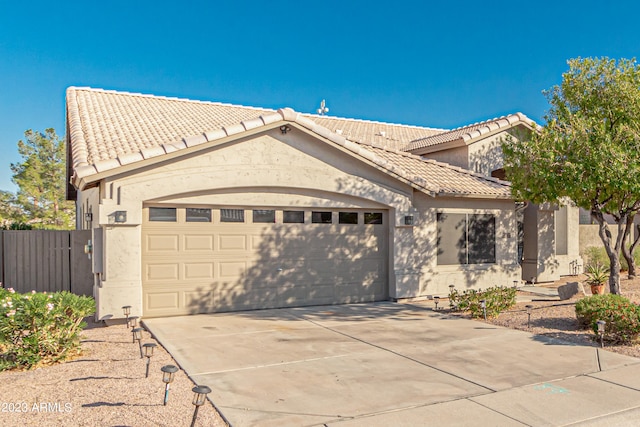 view of front of home featuring a garage, driveway, a tile roof, and stucco siding