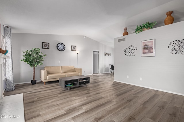 living room featuring hardwood / wood-style flooring and vaulted ceiling