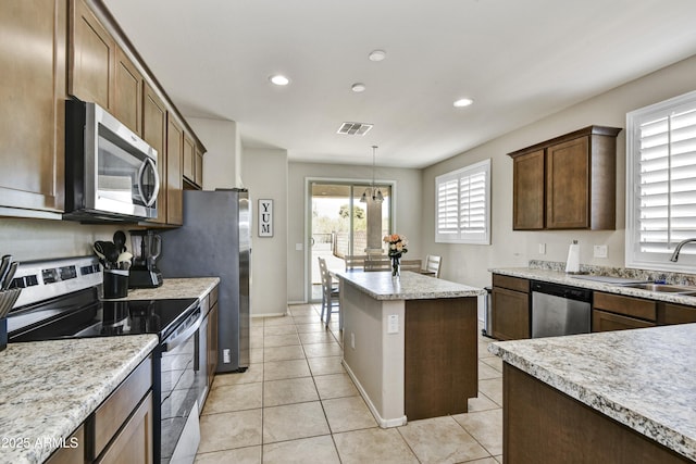 17626 W Paraiso Dr, Surprise, AZ 85387 - kitchen featuring stainless steel appliances, recessed lighting, a kitchen island, light tile patterned flooring, and pendant lighting