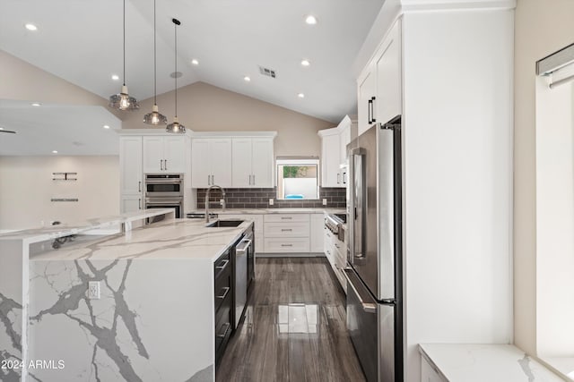 kitchen with appliances with stainless steel finishes, sink, decorative light fixtures, a center island with sink, and white cabinets