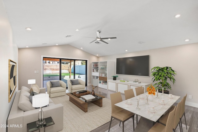 living room with ceiling fan, light hardwood / wood-style floors, and vaulted ceiling