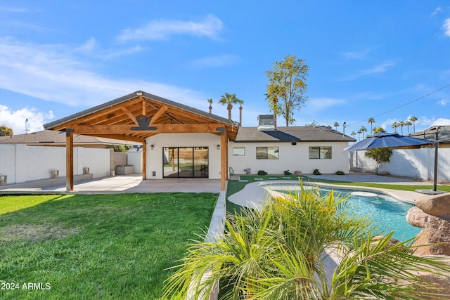 rear view of house featuring a fenced in pool, a patio area, and a lawn