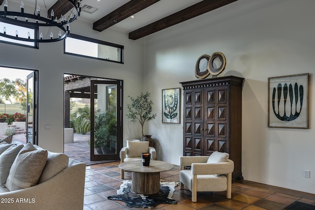 living room with a high ceiling, a notable chandelier, and beam ceiling