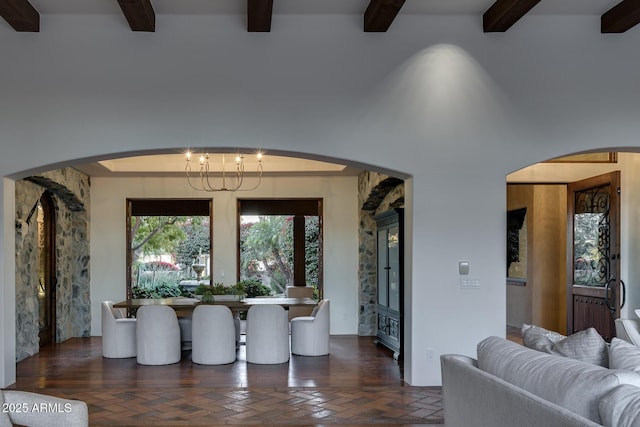 dining area featuring a notable chandelier and beam ceiling