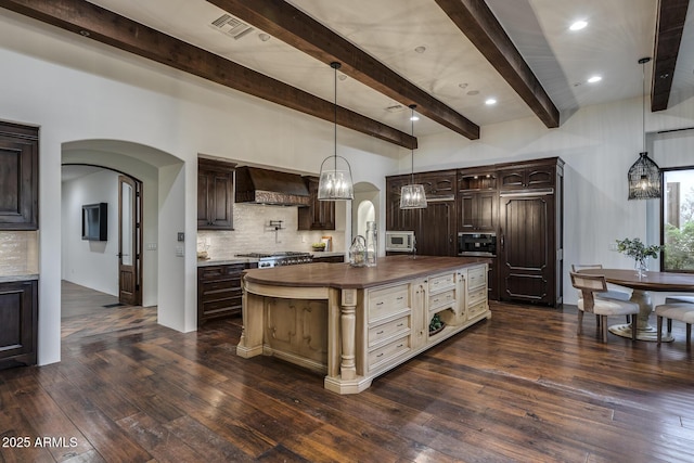 kitchen featuring decorative backsplash, stainless steel microwave, dark hardwood / wood-style floors, and custom range hood