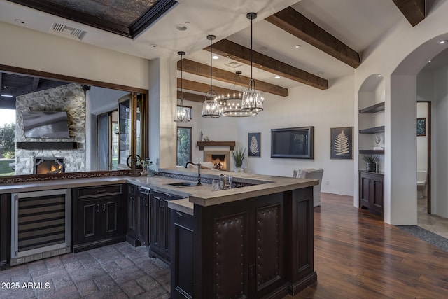 kitchen with sink, built in features, decorative light fixtures, beverage cooler, and beamed ceiling