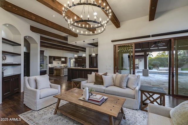 living room with a notable chandelier, dark wood-type flooring, and beamed ceiling