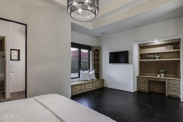 bedroom featuring an inviting chandelier, dark hardwood / wood-style flooring, and built in desk