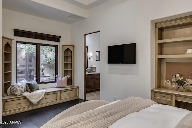 bedroom with dark wood-type flooring and connected bathroom