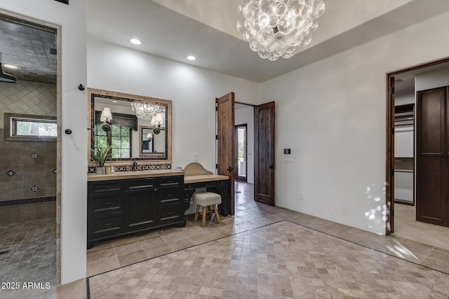 bathroom featuring vanity, a tile shower, and a notable chandelier