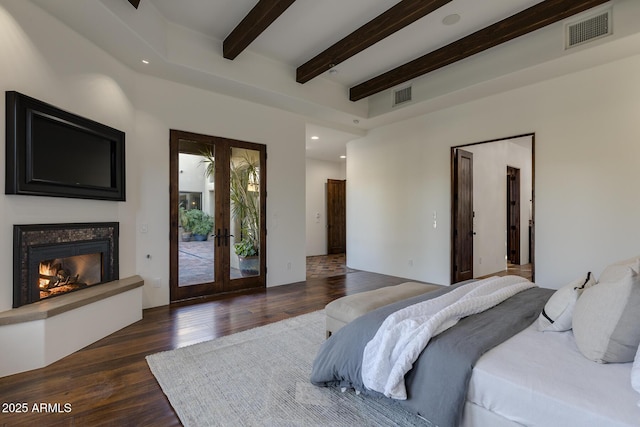 bedroom with beam ceiling, dark hardwood / wood-style floors, a high end fireplace, access to outside, and french doors