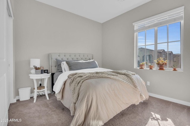 bedroom with baseboards and light colored carpet