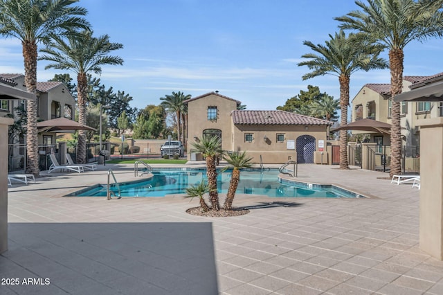 pool featuring fence and a patio