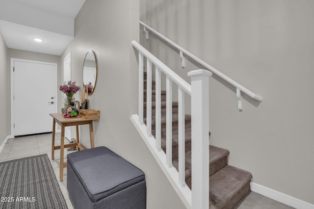 staircase featuring baseboards and tile patterned floors