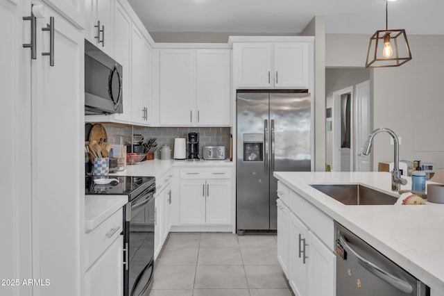 kitchen with a sink, white cabinets, appliances with stainless steel finishes, tasteful backsplash, and pendant lighting