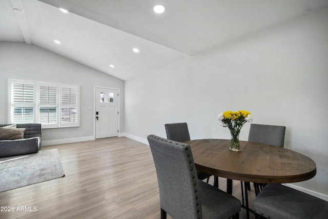 dining room featuring vaulted ceiling and light hardwood / wood-style floors