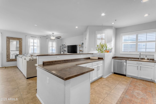 kitchen with white cabinetry, sink, stainless steel dishwasher, and light tile patterned flooring