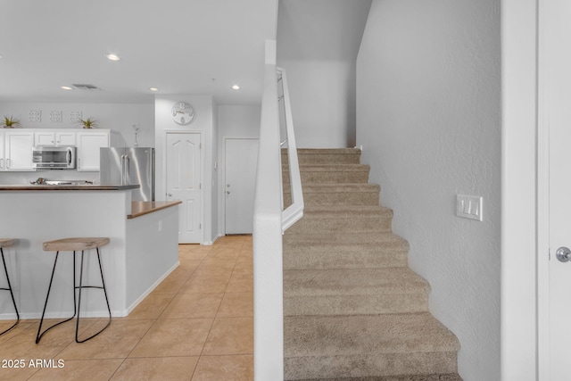 staircase featuring tile patterned flooring