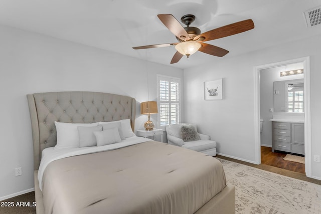 bedroom featuring dark hardwood / wood-style flooring, connected bathroom, and ceiling fan