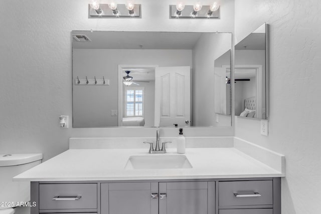 bathroom with vanity, ceiling fan, and toilet