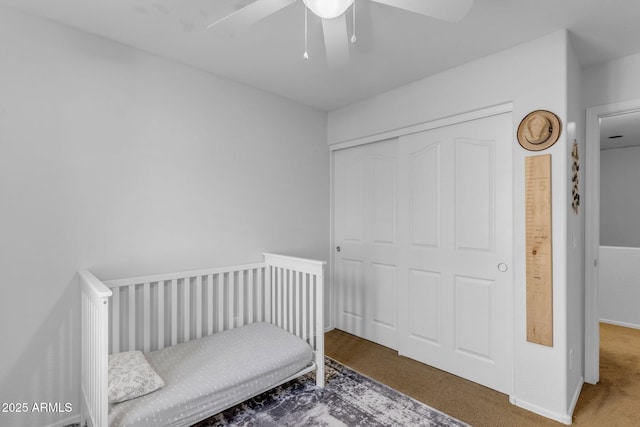 carpeted bedroom featuring ceiling fan and a closet