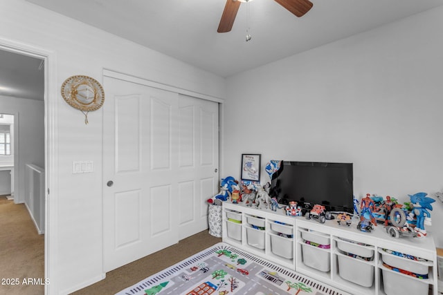 recreation room with ceiling fan and carpet