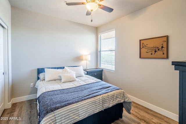 bedroom featuring a ceiling fan, baseboards, and wood finished floors