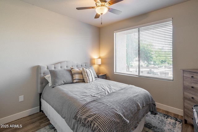 bedroom with a ceiling fan, baseboards, and wood finished floors