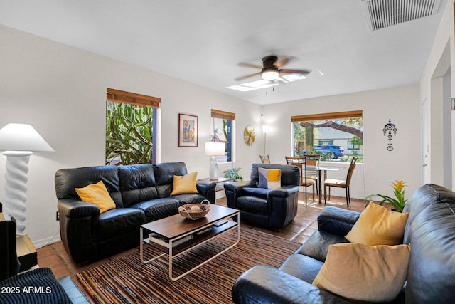 tiled living area with visible vents, baseboards, and a ceiling fan