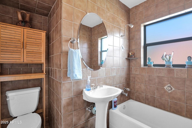 bathroom featuring a shower, a tub to relax in, toilet, and tile walls