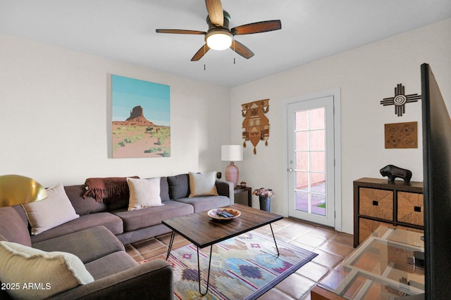 living area with a ceiling fan and tile patterned flooring