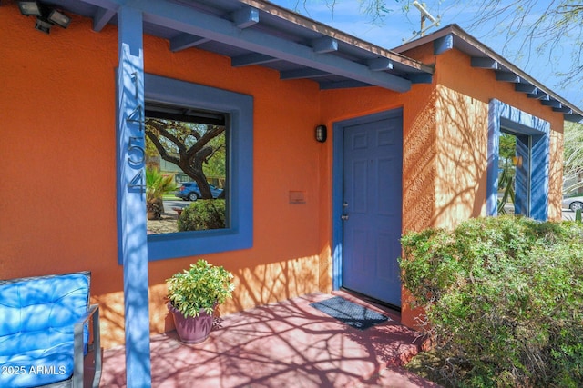 doorway to property featuring stucco siding