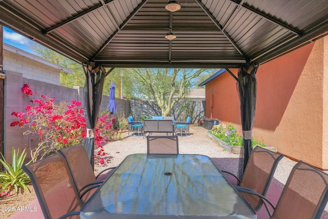 view of patio / terrace featuring a gazebo, outdoor dining area, an outdoor hangout area, and a fenced backyard