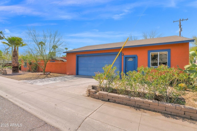 view of front of home featuring a garage, driveway, and stucco siding