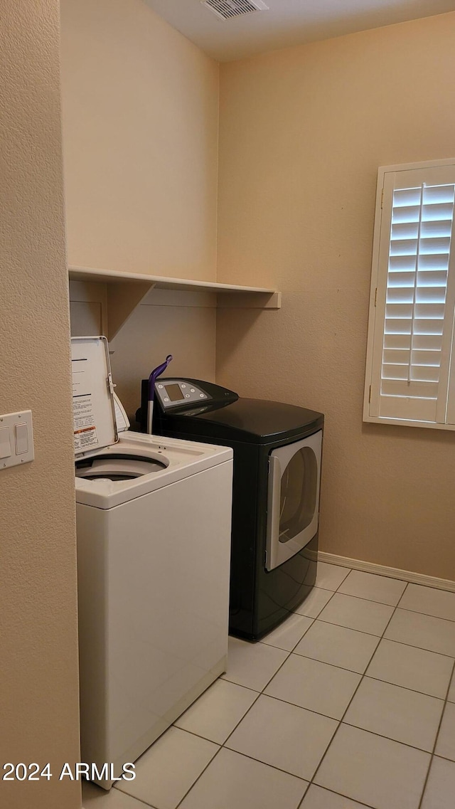 laundry room with separate washer and dryer and light tile patterned floors