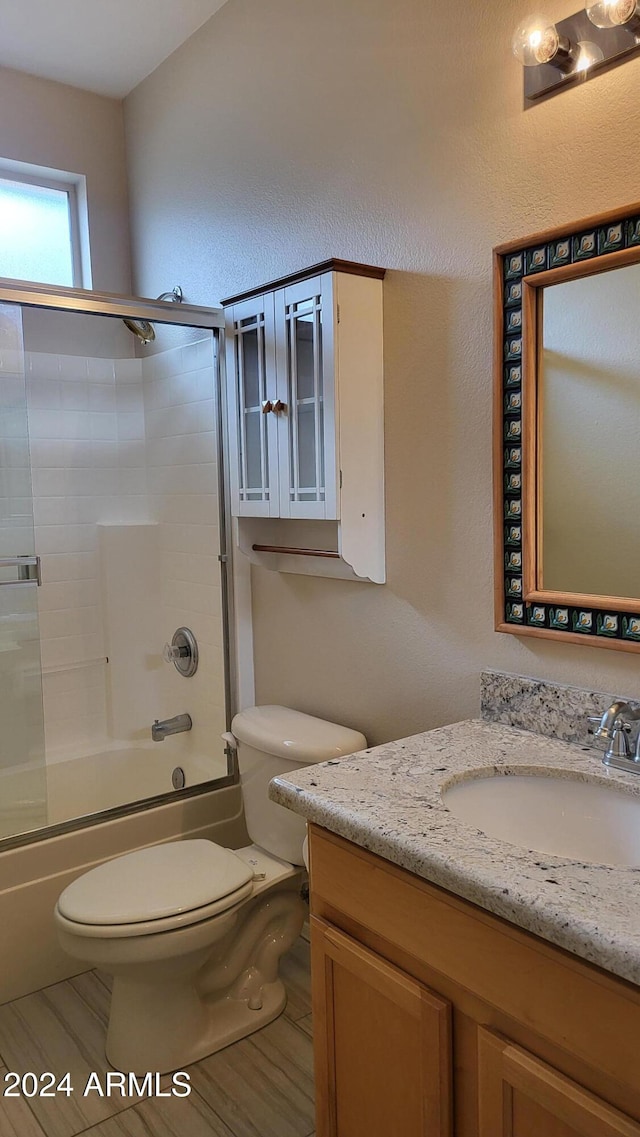 full bathroom featuring vanity, enclosed tub / shower combo, wood-type flooring, and toilet