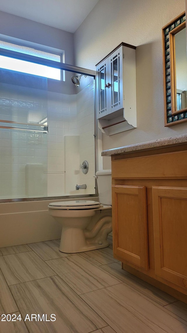 full bathroom with vanity, toilet, and bath / shower combo with glass door