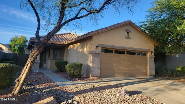 3347 W Steinbeck Dr, Anthem, AZ 85086 - view of front of home featuring fence, concrete driveway, a tile roof, an attached garage, and stucco siding