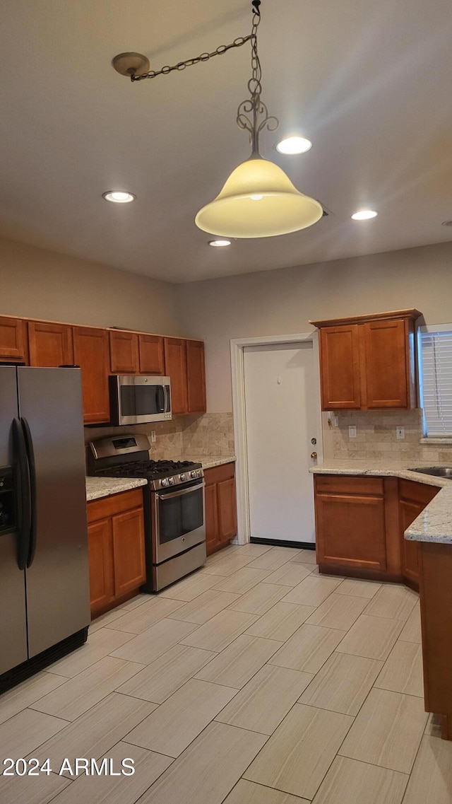 3347 W Steinbeck Dr, Anthem, AZ 85086 - kitchen with tasteful backsplash, stainless steel appliances, and brown cabinets