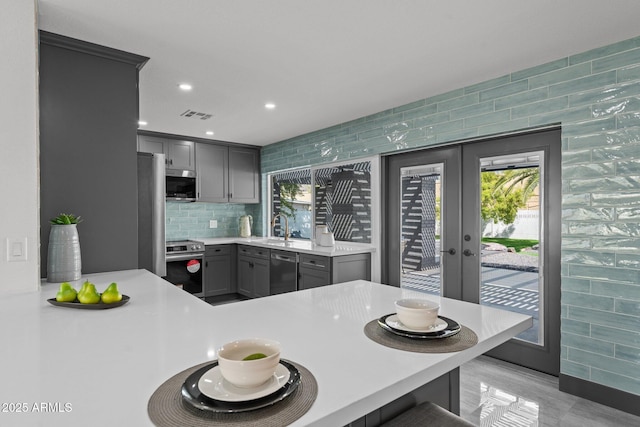 kitchen with gray cabinetry, visible vents, a wealth of natural light, and stainless steel appliances