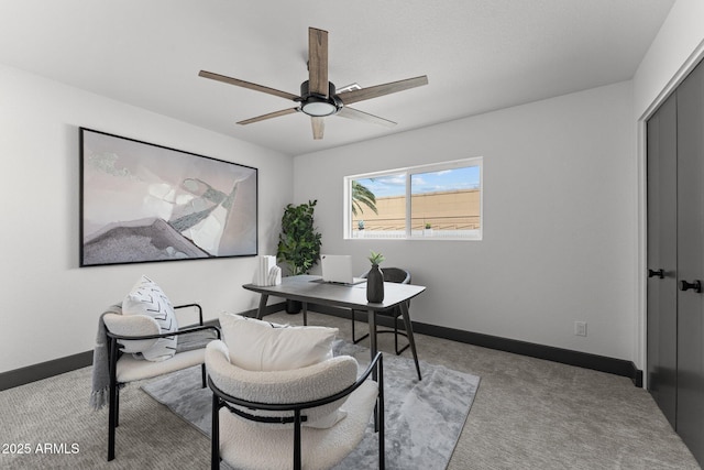 office area featuring a ceiling fan, light colored carpet, and baseboards