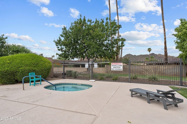 view of swimming pool with a mountain view, a patio area, a hot tub, and fence