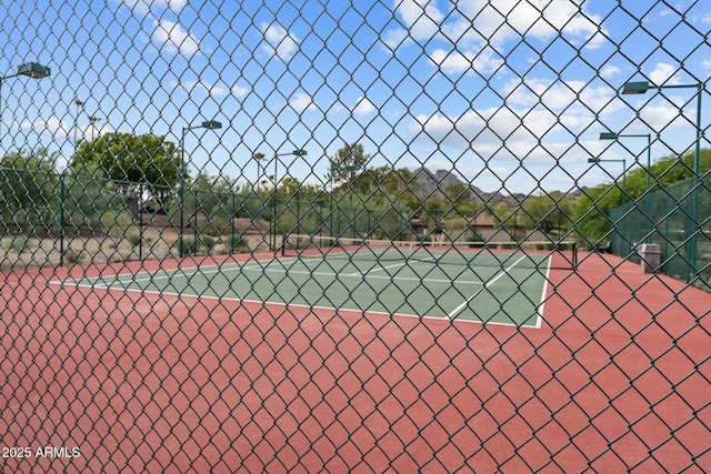 view of tennis court featuring fence