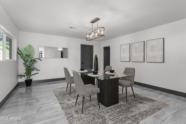 dining space featuring visible vents, an inviting chandelier, and baseboards