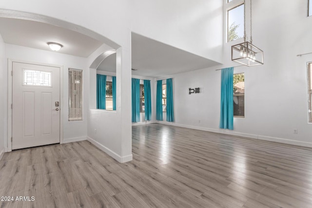 entrance foyer with light hardwood / wood-style floors and an inviting chandelier