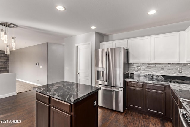 kitchen with stainless steel fridge, dark hardwood / wood-style flooring, white cabinetry, and dark stone counters