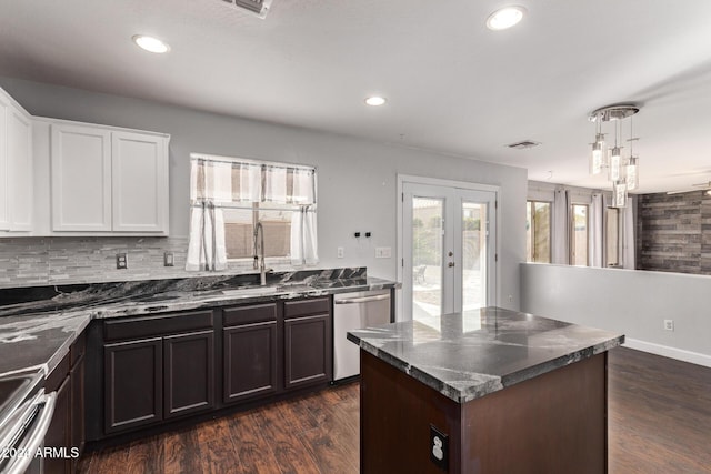 kitchen featuring white cabinets, dark hardwood / wood-style flooring, a center island, and stainless steel dishwasher