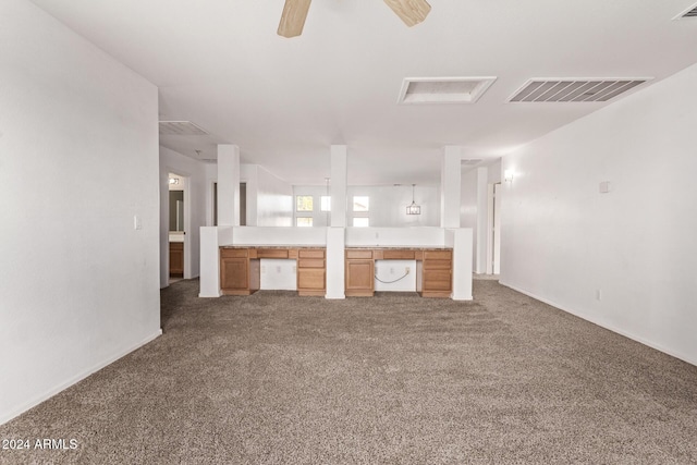 unfurnished living room with ceiling fan and dark colored carpet