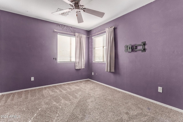 carpeted spare room featuring ceiling fan